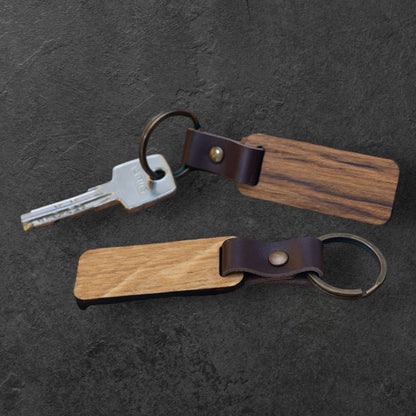 Nyckelring i trä av oljad ek med mörkbrun läderrem